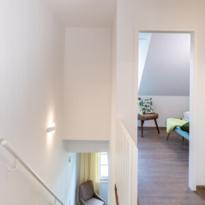 Blick vom Flur in das Elternschlafzimmer der oberen Etage und die Treppe zum Wohnbereich der Ferienwohnung P7. Die exklusive Ferienwohnung für 4 Personen liegt in der Residenz Kormoran in Prerow. Blick vom Flur in das Elternschlafzimmer der oberen Etage und die Treppe zum Wohnbereich der Ferienwohnung P7. Die exklusive Ferienwohnung für 4 Personen liegt in der Residenz Kormoran in Prerow.